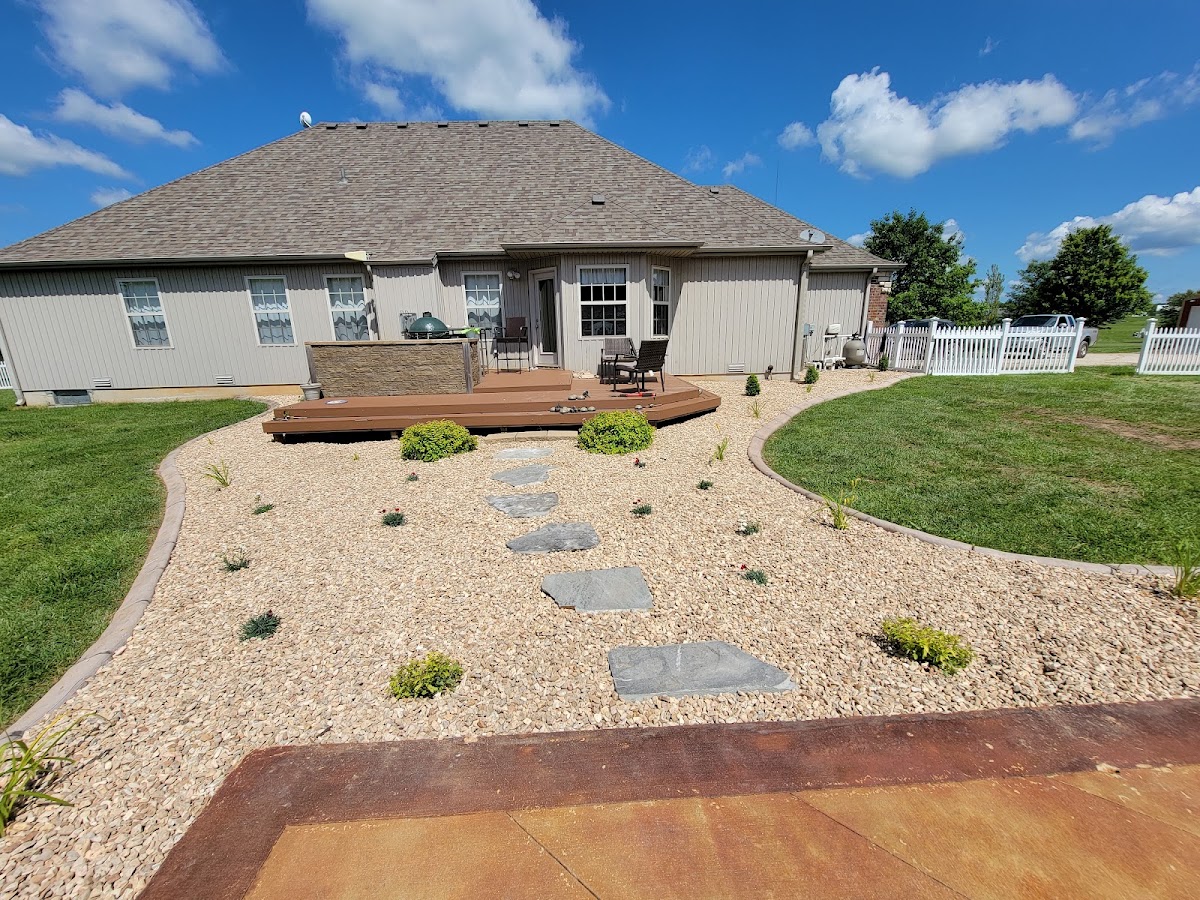 Backyard rock garden with stepping stones beside a deck