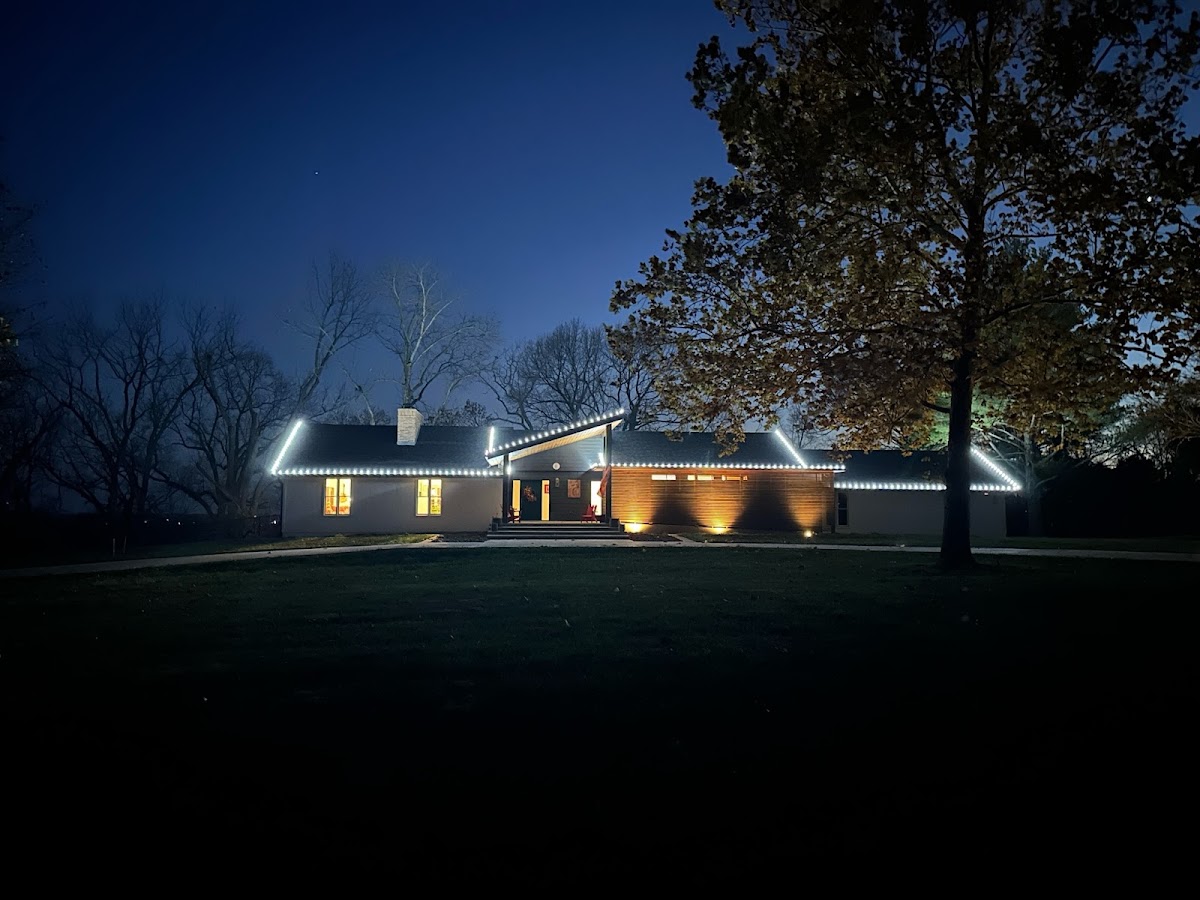 Home at dusk with roofline and porch lighting