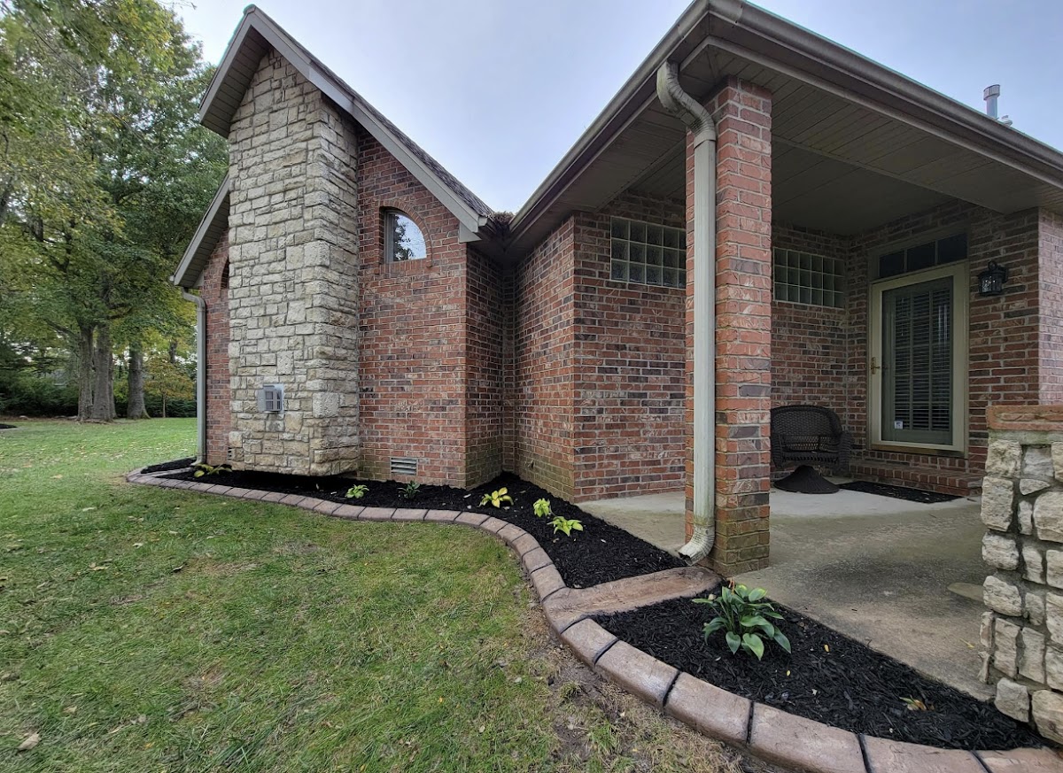 New landscape bed with concrete curb edging, mulch and hostas