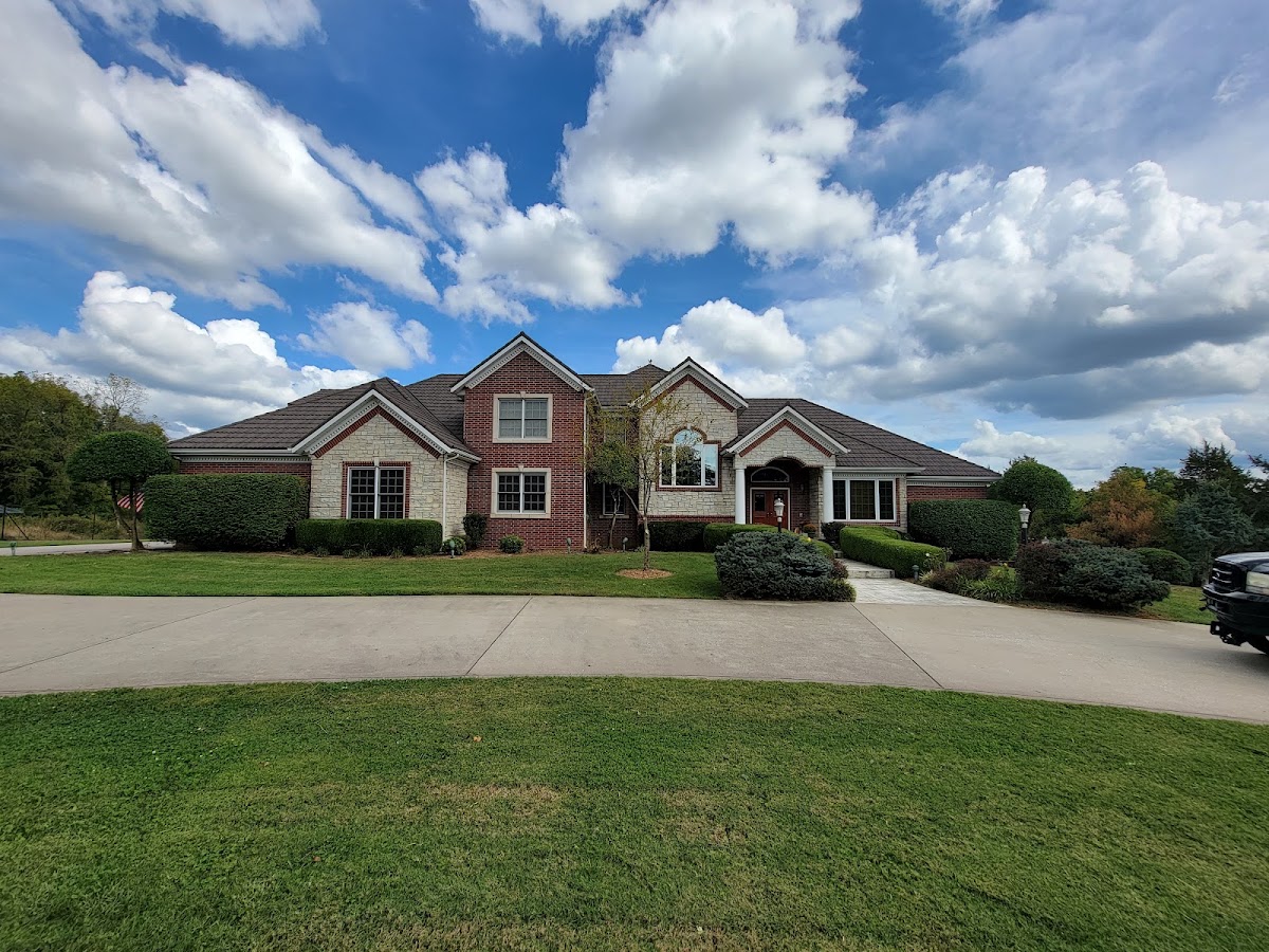 Green front lawn in front of a brick home
